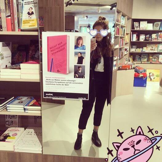 selfie in mirror at the bookshop 
														  with advertisement for the bookrelease of 
														  Nicht nur Mütter waren schwanger